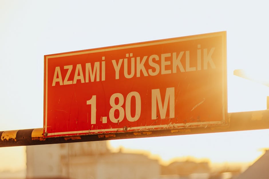 A red maximum height sign with sunlight in the background, reading ‘Azami Yukseklik 1.80 M’. A red maximum height sign with sunlight in the background, reading 'Azami Yukseklik 1.80 M'.