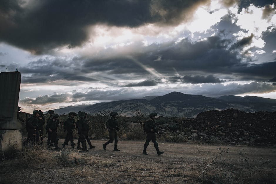 A group of soldiers march through a rugged landscape under a threatening sky in Israel. A group of soldiers march through a rugged landscape under a threatening sky in Israel.