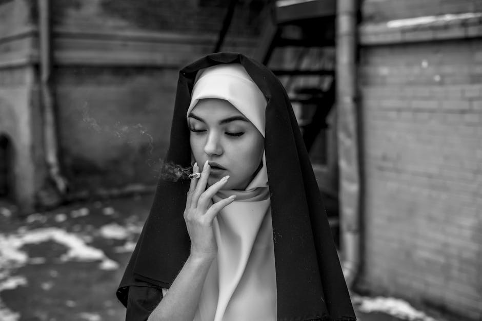 An intriguing black and white portrait of a nun smoking outdoors. An intriguing black and white portrait of a nun smoking outdoors.