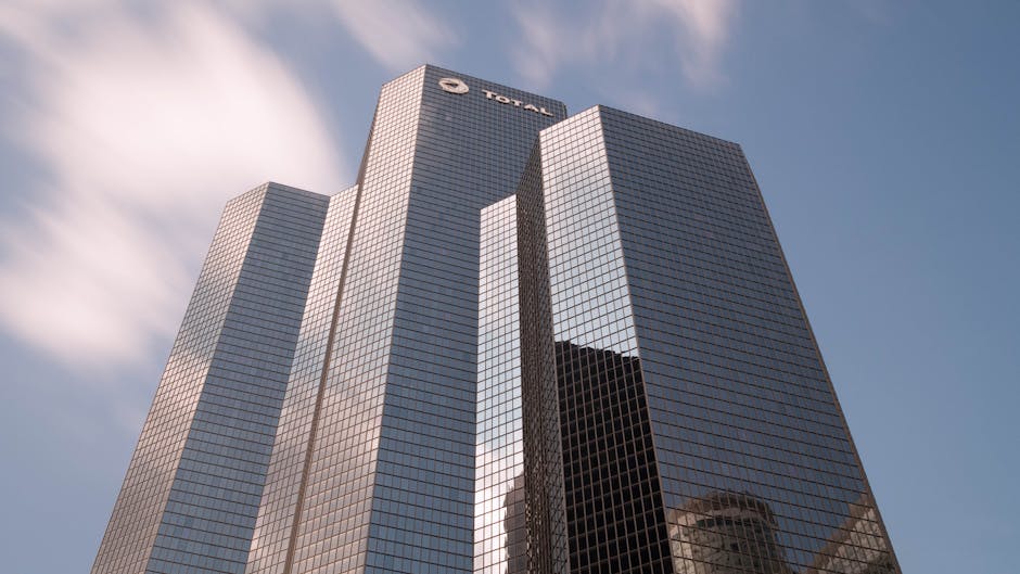 Low angle view of a modern glass skyscraper in Courbevoie, France. Low angle view of a modern glass skyscraper in Courbevoie, France.