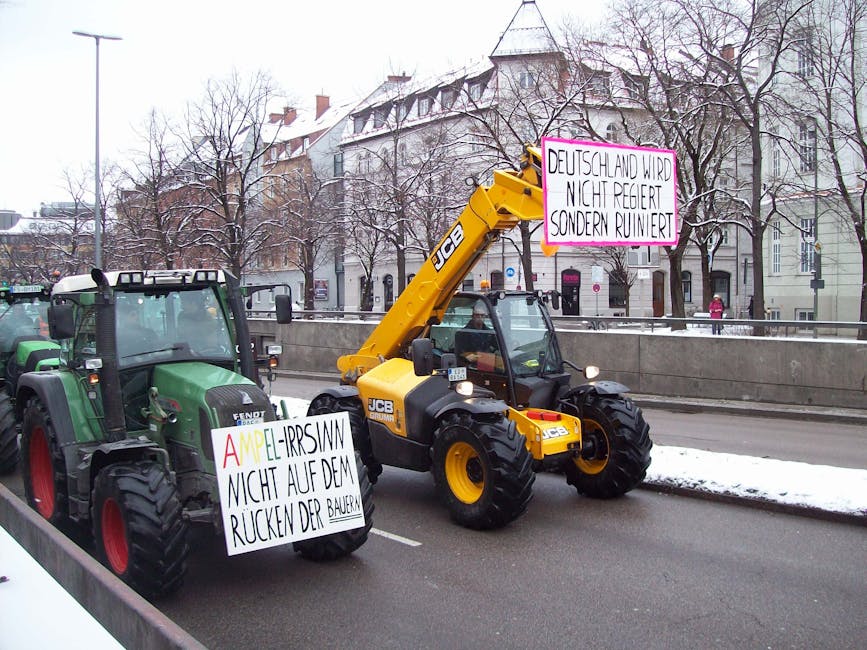 Tractors on a city street protesting with signs during a snowy winter day. Tractors on a city street protesting with signs during a snowy winter day.