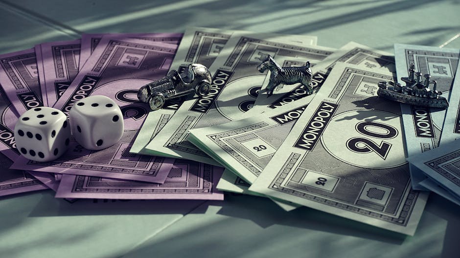 Close-up of Monopoly game components including dice and miniature pieces on colorful cash. Close-up of Monopoly game components including dice and miniature pieces on colorful cash.