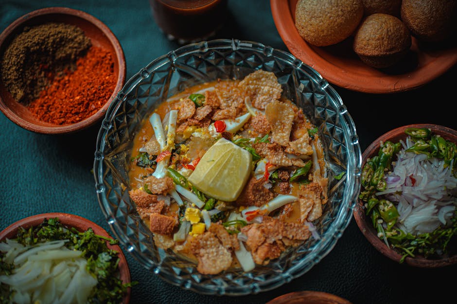 Top view of a vibrant Indian dish with lemon, spices, and crunchy toppings, perfect for food lovers.