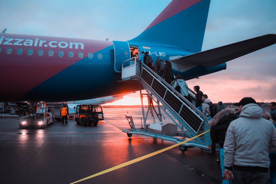Passengers boarding an airplane at sunset with a vivid sky in the background, capturing a travel moment. Passengers boarding an airplane at sunset with a vivid sky in the background, capturing a travel moment.
